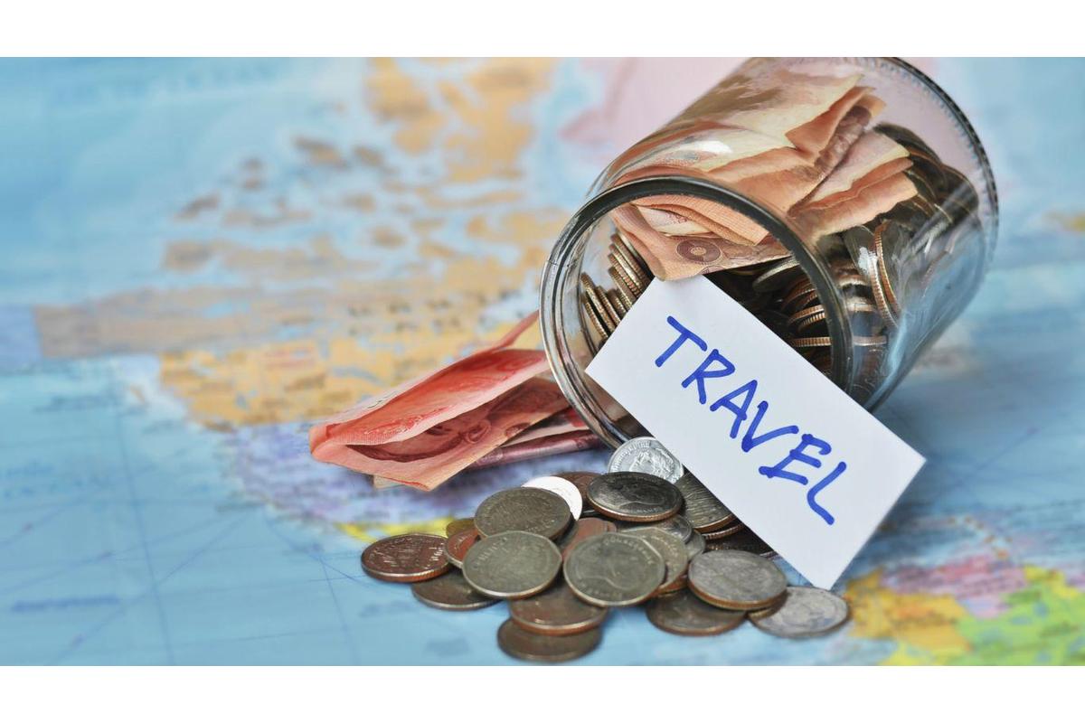 Zaino, mappa e portafoglio con pochi soldi su un tavolo di legno. Viaggiare low cost.